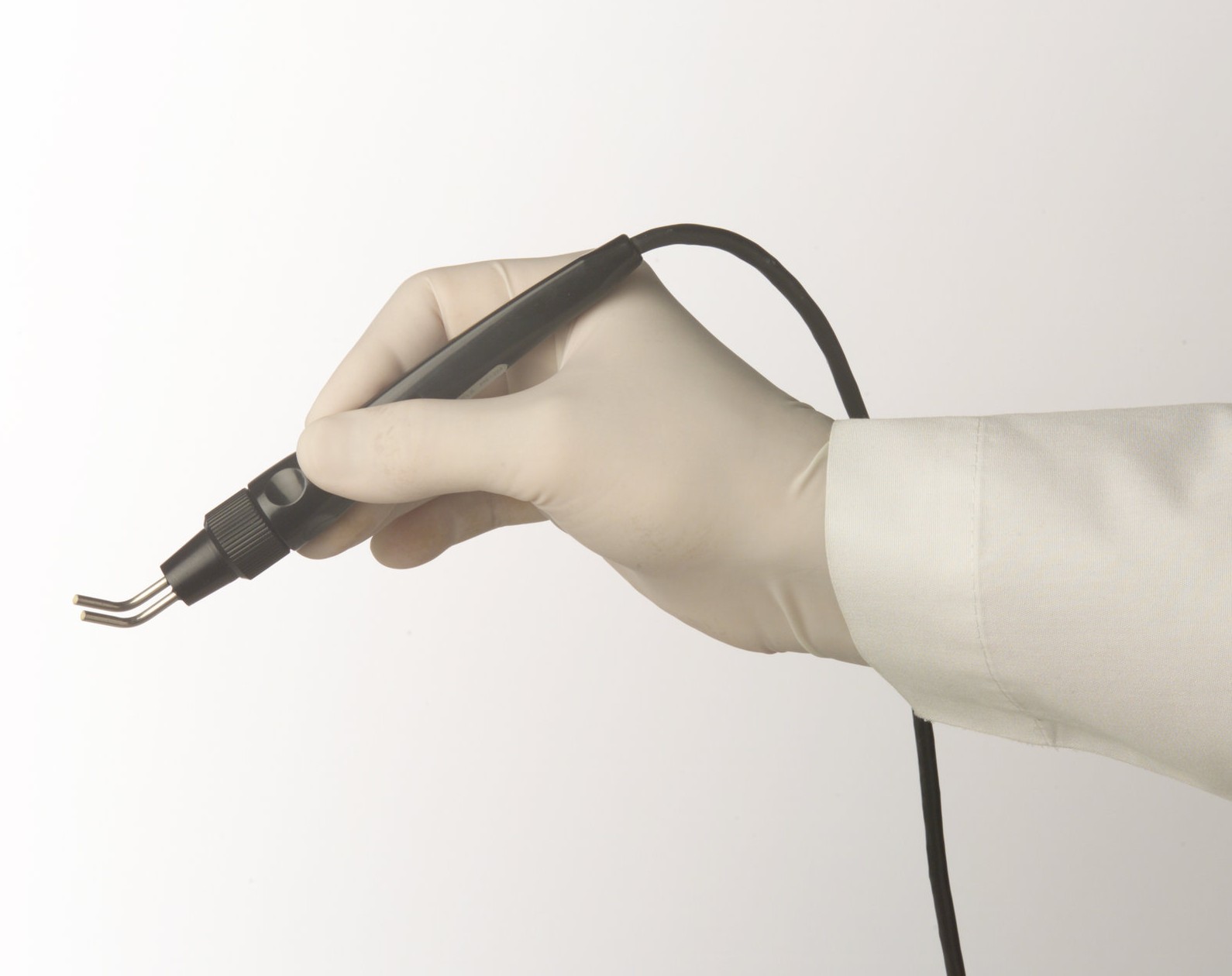 Gloved hand holding the ThermoMed handpiece published by Thermosurgery Technologies